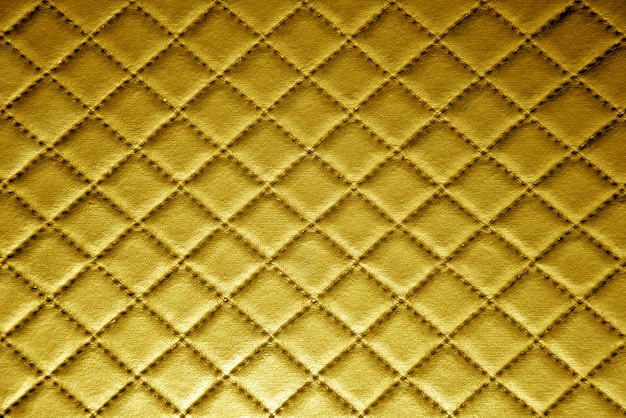 Textura de couro de ouro com fundo de costura