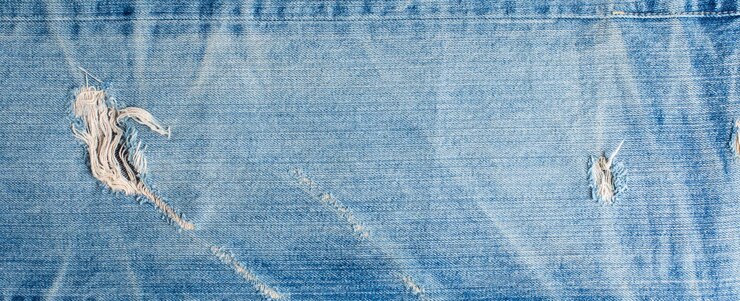 Foto textura de design de jeans de moda jeans rasgado. banner de textura de jeans jeans azul com espaço de cópia para plano de fundo do texto. textura de moda jeans de lona. banner panorâmico de moda