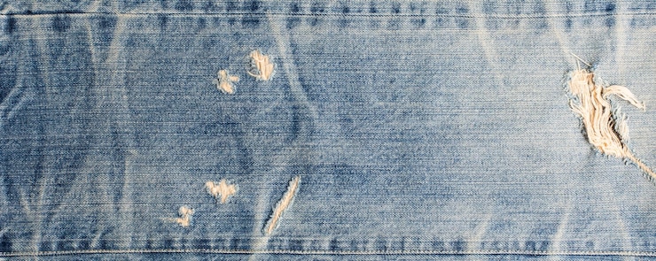 Foto textura de design de jeans de moda rasgada banner de textura de jeans azul com espaço de cópia para fundo de design de texto textura de moda de jeans de lona banner de moda panorâmico