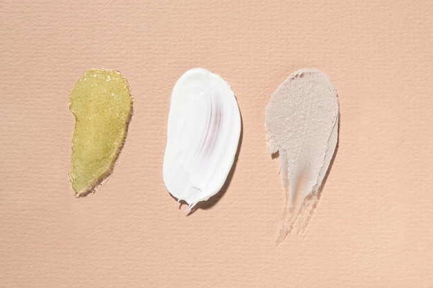 Textura de diferentes produtos cosméticos em um gel hialurônico de creme corporal com vista superior de fundo bege