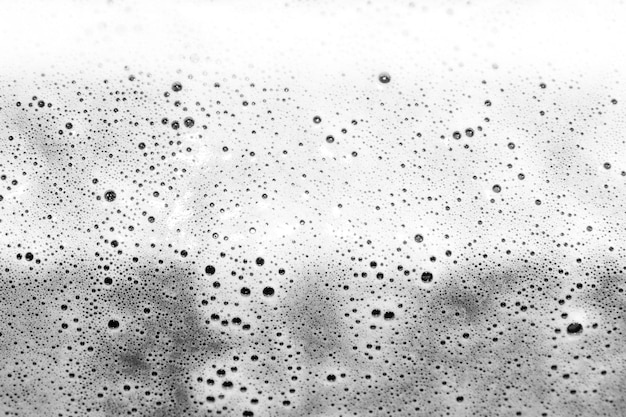 Textura de espuma branca As bolhas estouram e se espalham O líquido químico ferve e assobia