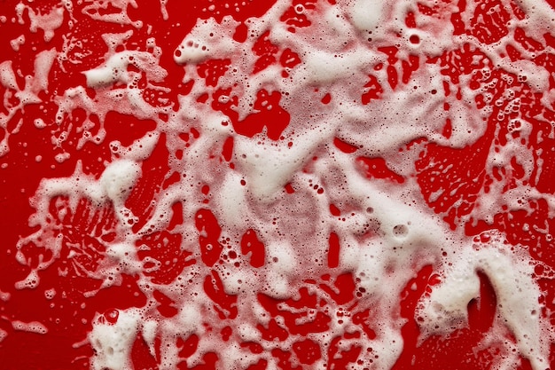 Textura de espuma de sabão branco com bolhas de fundo vermelho abstrato Sabonete gel shampoo para rosto Creme de limpeza amostra de mousse