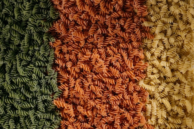 Textura de fundo de macarrão fusilli tricolor para cozinha tradicional italiana e mediterrânea em uma visão de quadro completo de perto. Foto de alta qualidade