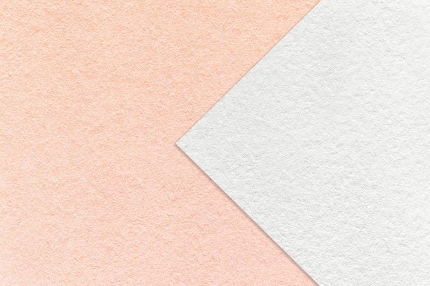 Textura de fundo de papel branco e rosa metade de duas cores com macro de seta estrutura de papelão coral artesanal denso