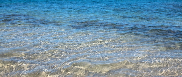 Textura de fundo do mar de verão da superfície da água brilhando com padrão de ondulação de água azul