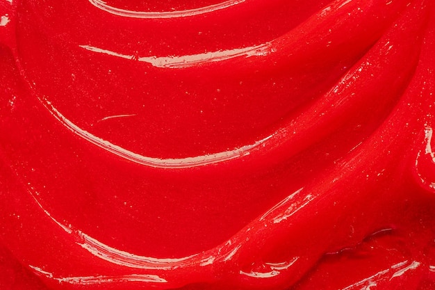 Textura de gel vermelho Mancha de creme líquido claro cosmético Amostra de produto de cuidados com a pele closeup Pasta de dentes ou cera