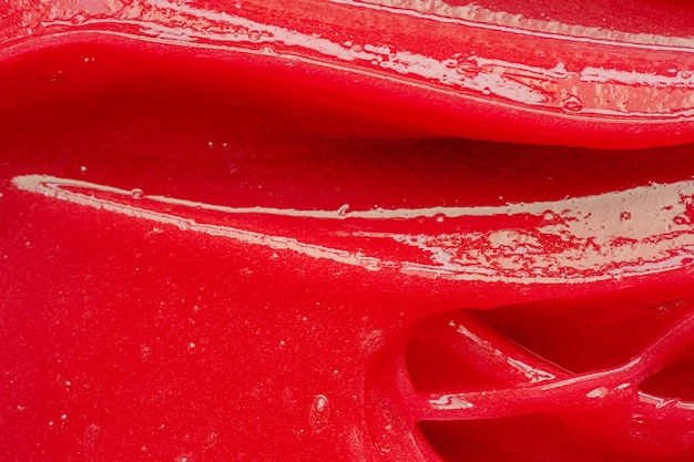 Textura de gel vermelho Mancha de creme líquido claro cosmético Amostra de produto de cuidados com a pele closeup Pasta de dentes ou cera