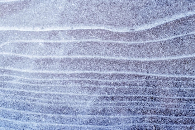 Textura de gelo com rachaduras de gelo ligeiramente cobertas de neve