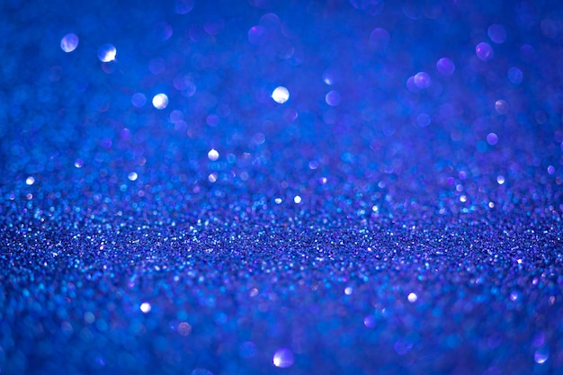 Textura de glitter azul brilhante. foco seletivo. superfície brilhante, luzes cintilantes e efeitos bokeh. natal e foto festiva do fundo