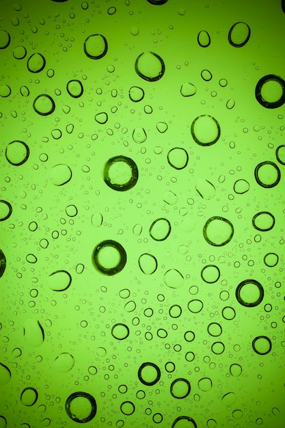 Foto textura de gotas de água em vidro verde.