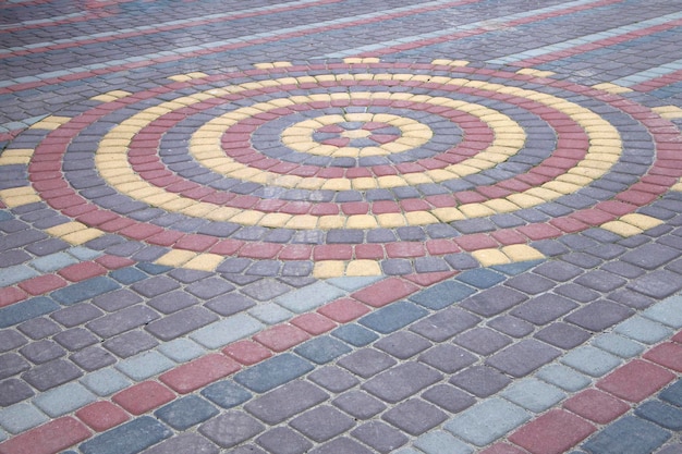 Textura de lajes de pavimentação de concreto com padrão vermelho e amarelo cinza na base da perspectiva da rua