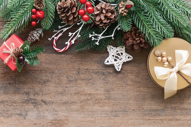 Textura de madeira antiga decorar com folhas de pinheiro, pinhas, bolas de azevinho e caixa de presente no conceito de tema de Natal