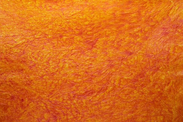 Textura de papel artesanal com fibras de pergaminho. em laranja, amarelo, cores avermelhadas intensas.