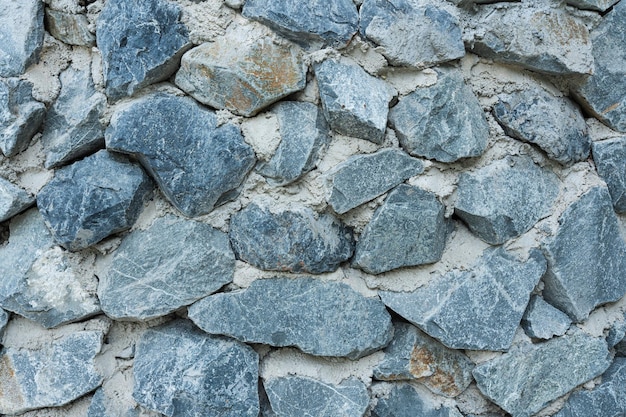 Foto textura de parede de pedra robusta fundo em tons cinzentos e castanhos com padrões abstratos de granito