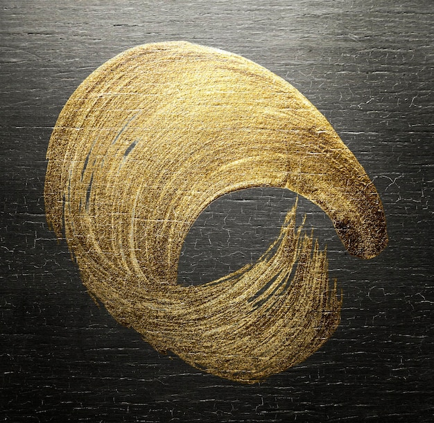 Textura de pincel de tinta a óleo de ouro em um fundo de madeira colorido