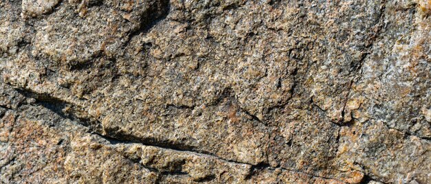 Textura de rocha de granito. Superfície de granito rachada por intempéries. Close-up da superfície da pedra. Conceito de cor da terra