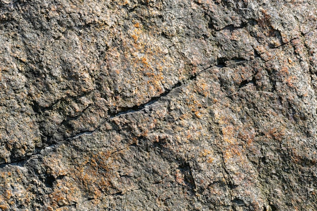Textura de rocha de granito. Superfície de pedra rachada por intempéries. Perto da superfície do granito. Conceito de cor da terra