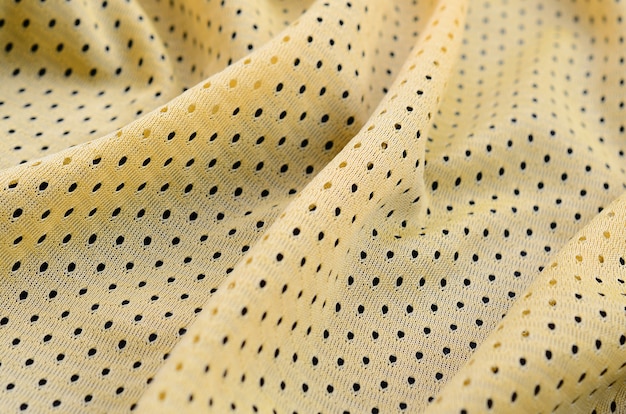 Foto textura de tecido de roupa esporte jersey amarelo e fundo com muitas dobras