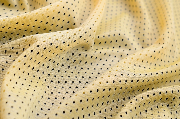 Textura de tecido de roupa esporte jersey amarelo e fundo com muitas dobras