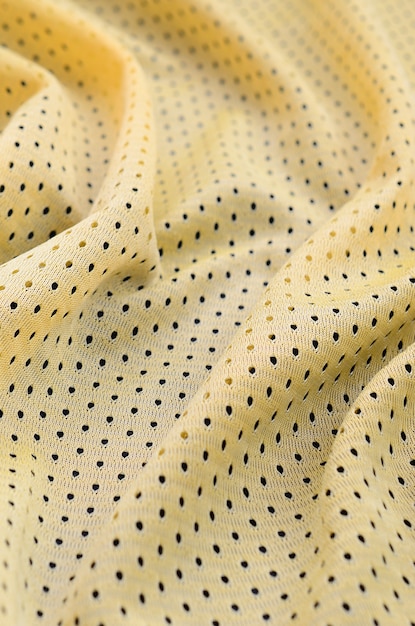 Textura de tecido de roupa esporte jersey amarelo e fundo com muitas dobras