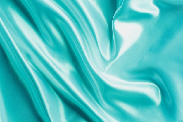 Textura de tecido de tecido de seda ou cetim de luxo Suave turquesa ondulada elegante, design de fundo abstrato