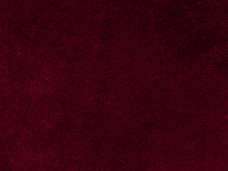 Foto textura de tecido de veludo vermelho usada como fundo fundo de tecido vermelho vazio de material têxtil macio e liso há espaço para texto