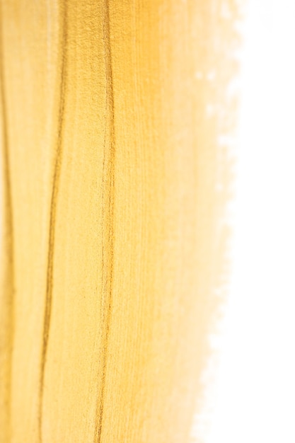 Textura de tinta dourada brilhante macro isolada no fundo branco com foco seletivo. Glitter dourado brilho elegante modelo suave para convite de festa ou casamento