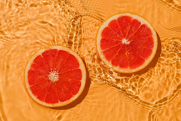 Textura de toranja fresca crua vermelha cítrica de verão com água fresca e ondas