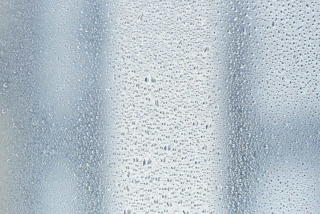 Textura de uma gota de chuva em um fundo transparente molhado de vidro