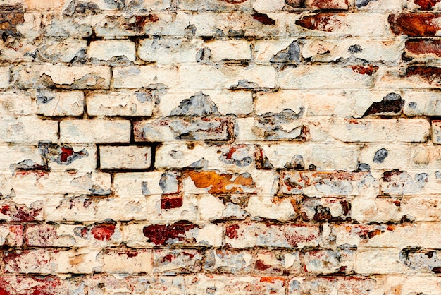 Textura de uma parede de tijolos com rachaduras e arranhões que podem ser usados como fundo