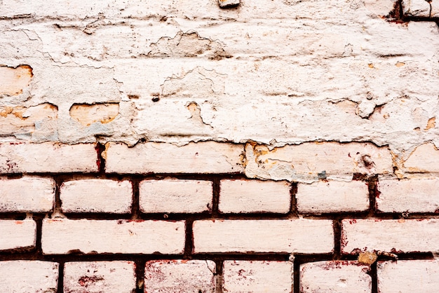 Foto textura de uma parede de tijolos com rachaduras e arranhões que podem ser usados como pano de fundo