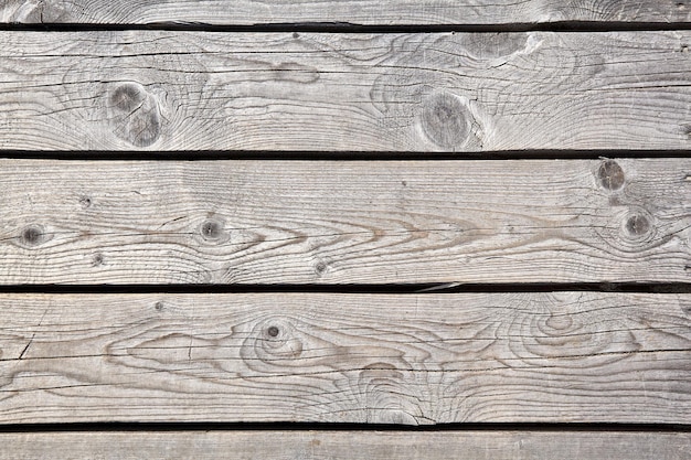 Textura desgastada de la tarima de madera del camino en las dunas cubiertas de arena