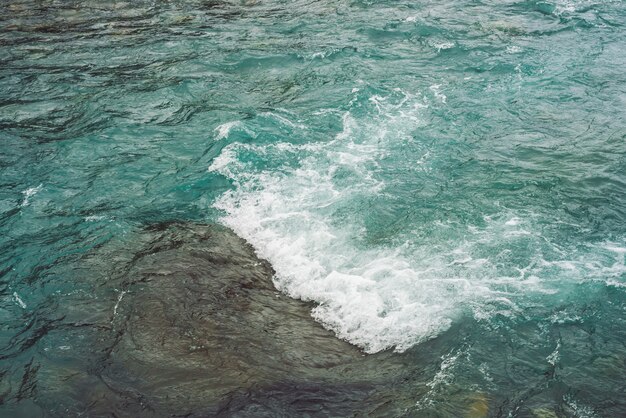 Textura detallada de la superficie del agua turquesa corriendo.