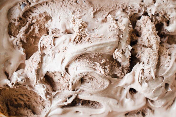 Textura do gelado de chocolate de derretimento. Fundo marrom.