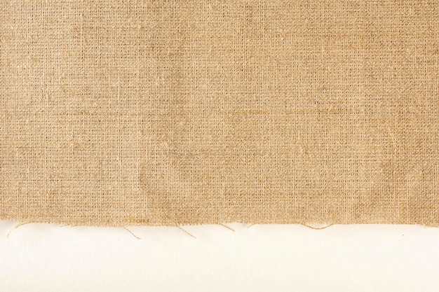 Textura do tecido de linho tecido de linho natural com uma borda crua em um fundo branco