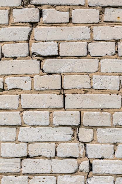 Textura e fundo de parede de tijolos de silicato branco rachado profundo