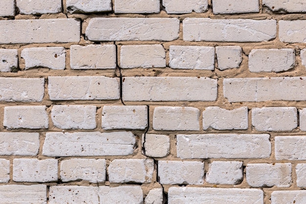 Textura e fundo de parede de tijolos de silicato branco rachado profundo