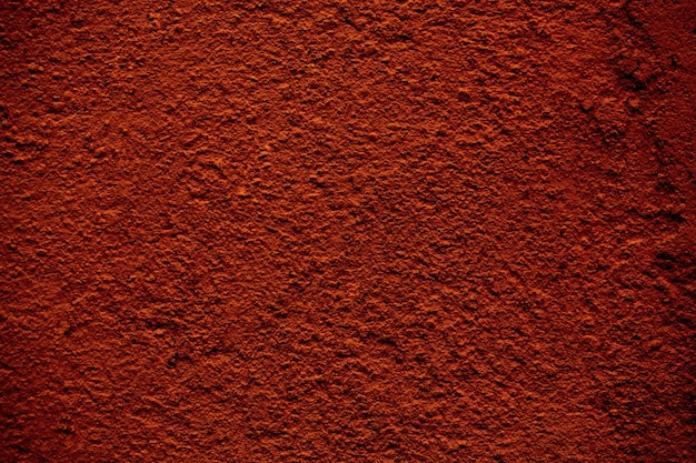 Textura de fondo de un muro de hormigón de acabado rugoso pintado en color marrón rojizo en una vista de fotograma completo.