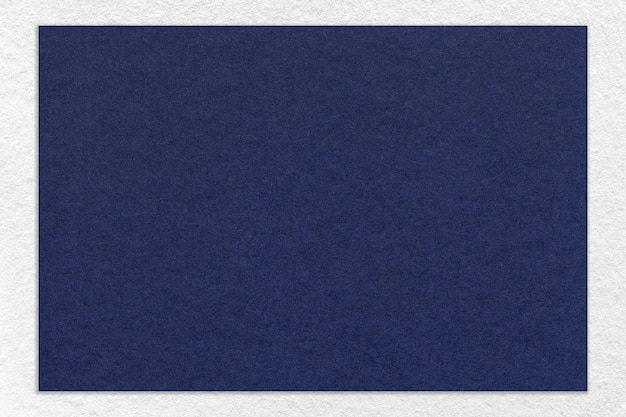 Textura de fondo de papel de color azul marino artesanal con borde blanco macro Cartón de mezclilla kraft denso vintage
