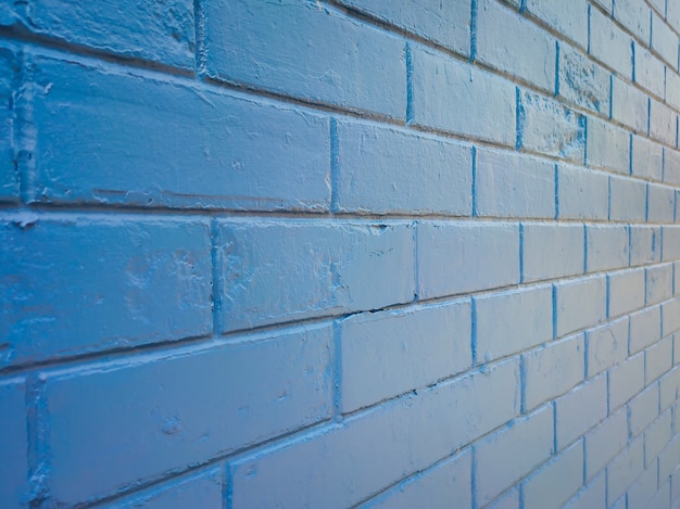 Textura y fondo de pared de ladrillo azul contra la luz del sol.