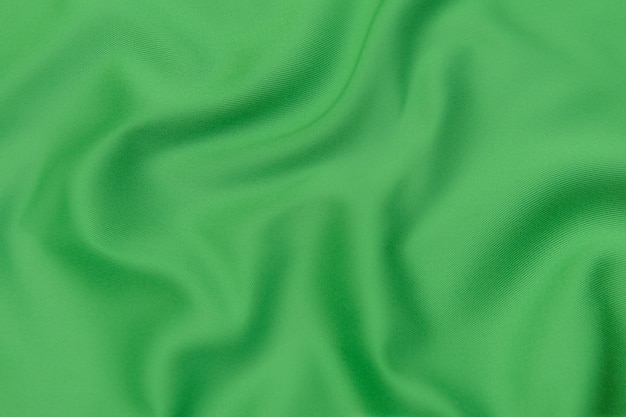 Textura, fondo, patrón. Textura de tela de seda verde. Preciosa tela de seda suave verde esmeralda.