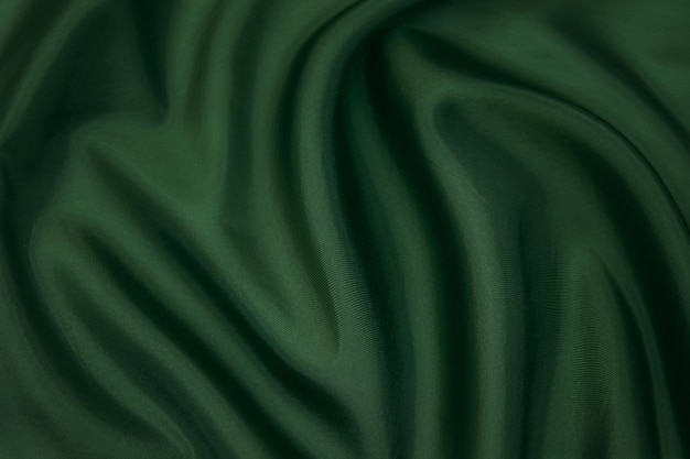 Textura, fondo, patrón. Textura de tela de seda verde. Preciosa tela de seda suave verde esmeralda.