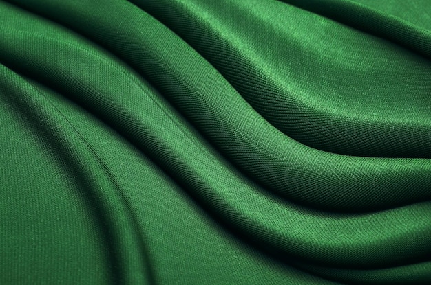 Textura, fondo, patrón. Textura de tela de seda verde. Preciosa tela de seda suave verde esmeralda.