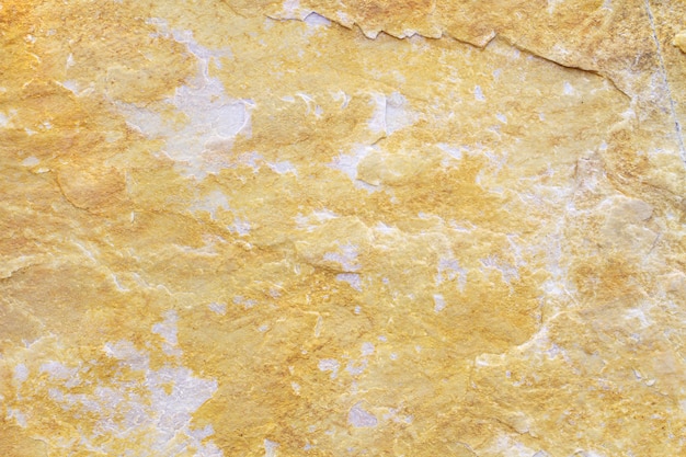 Textura de fondo de piedra natural con tonos beige, amarillo y gris.