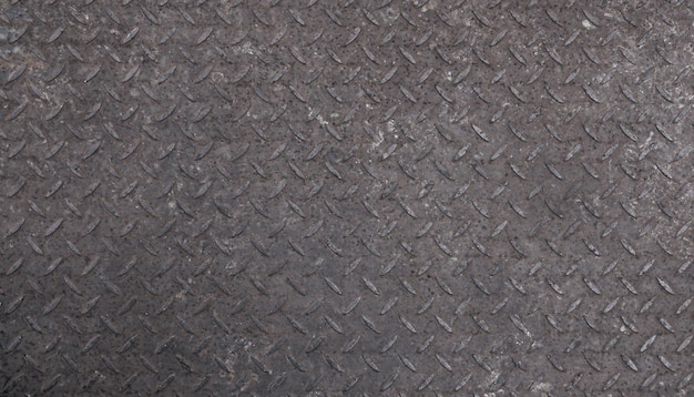 Textura de fondo de la superficie de la placa de acero de metal en relieve antideslizante industrial gris con protuberancias diagonales de patrón de diamante, de cerca