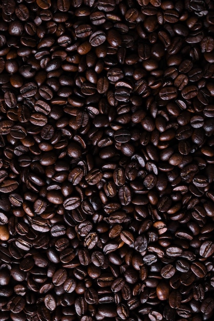 Textura fresca de los granos de café marrón del primer listo para beber asado.