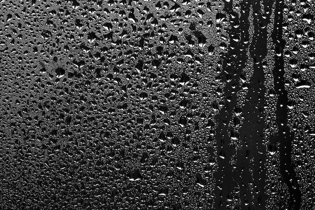 Textura de una gota de lluvia sobre un fondo transparente mojado de vidrio