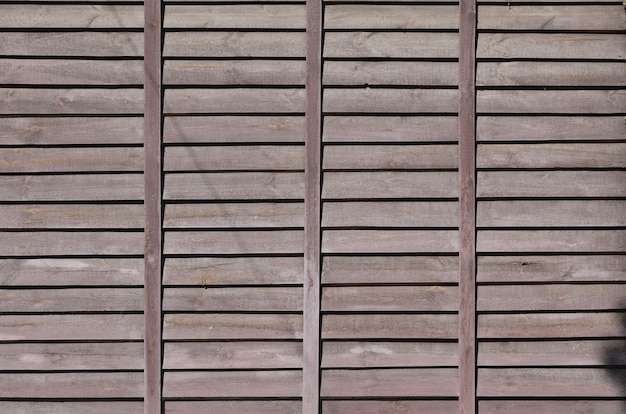 Foto textura horizontal de uma parede de várias linhas de tábuas de madeira velhas marrons