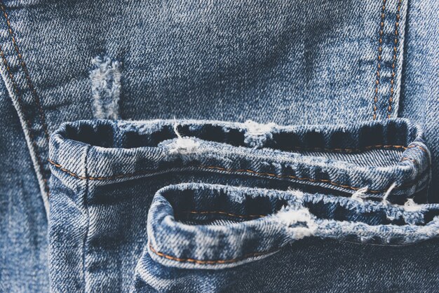 Textura jeans azul jeans com arranhões e buracos. fundo abstrato.