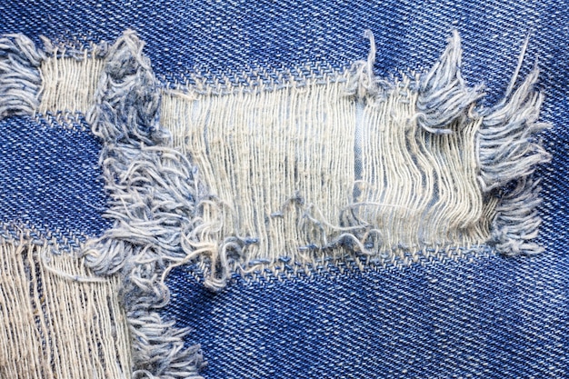 Foto textura de jeans de mezclilla rasgada azul.